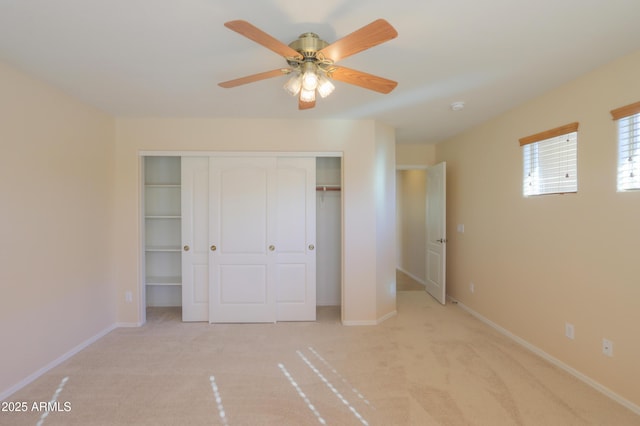 unfurnished bedroom featuring ceiling fan, a closet, and light colored carpet