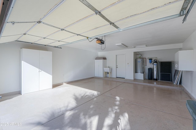 garage with electric water heater, sink, and a garage door opener