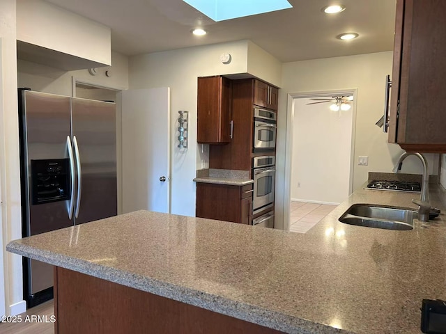 344 E Aepli Dr, Tempe, AZ 85282 - kitchen featuring stainless steel appliances, a skylight, recessed lighting, a peninsula, and light tile patterned flooring