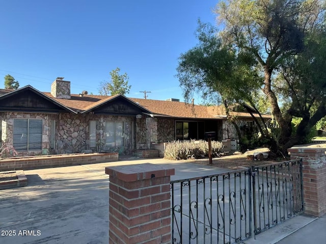 344 E Aepli Dr, Tempe, AZ 85282 - ranch-style house featuring a chimney, a fenced front yard, stone siding, and a gate
