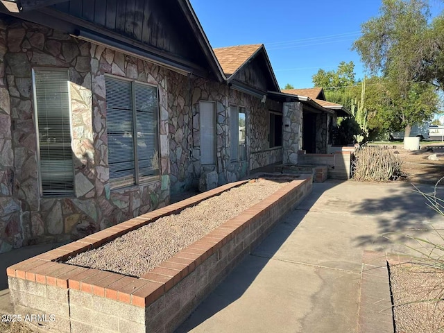 344 E Aepli Dr, Tempe, AZ 85282 - view of home's exterior featuring stone siding, a patio, and roof with shingles