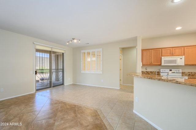 kitchen with light stone counters, range, and light tile patterned floors