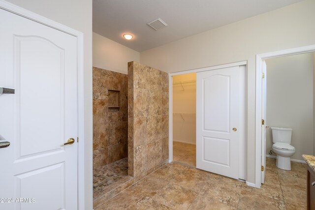 bathroom with toilet and tiled shower