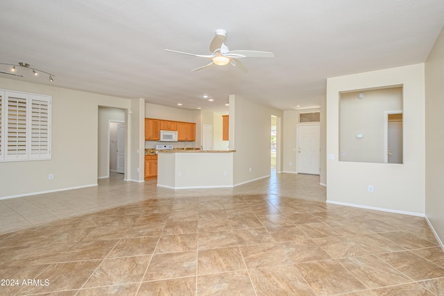 unfurnished living room featuring light tile patterned floors and ceiling fan