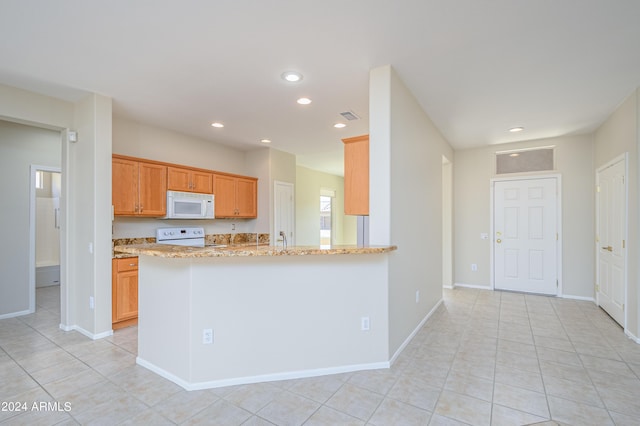 kitchen featuring light stone counters, white appliances, kitchen peninsula, and light tile patterned floors