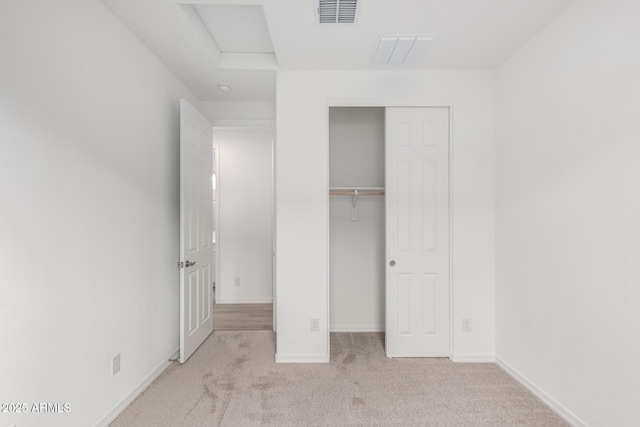 unfurnished bedroom featuring light carpet and a closet