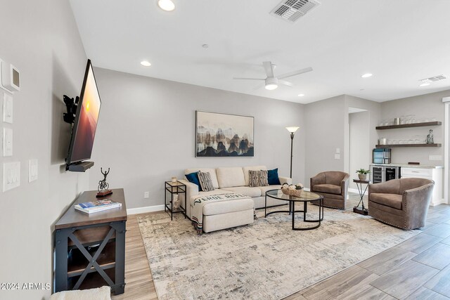 living room with light hardwood / wood-style flooring and ceiling fan