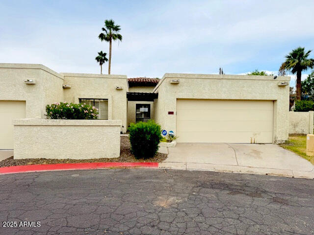 4727 E Euclid Ave, Phoenix, AZ 85044 - pueblo-style home with an attached garage, driveway, stucco siding, and a tiled roof