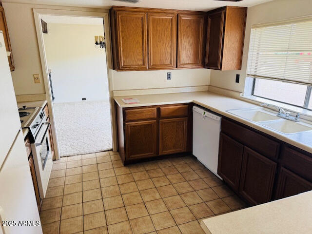 4727 E Euclid Ave, Phoenix, AZ 85044 - kitchen with white appliances, a sink, light countertops, light tile patterned floors, and brown cabinets
