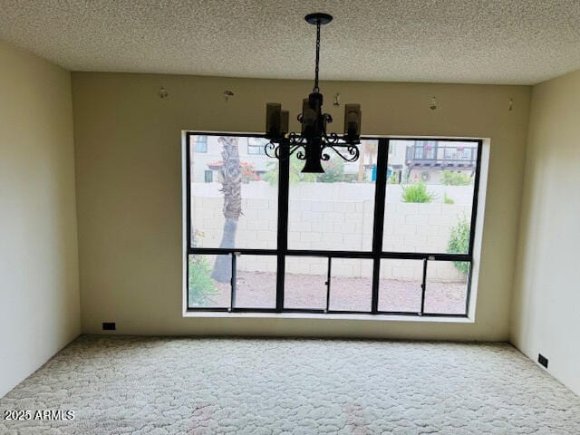4727 E Euclid Ave, Phoenix, AZ 85044 - unfurnished dining area featuring a chandelier, healthy amount of natural light, carpet, and a textured ceiling
