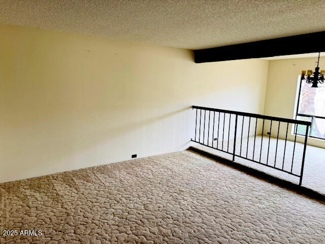 4727 E Euclid Ave, Phoenix, AZ 85044 - unfurnished room featuring carpet floors, a chandelier, a textured ceiling, and beam ceiling