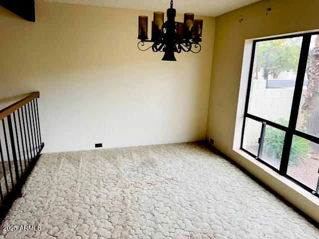 4727 E Euclid Ave, Phoenix, AZ 85044 - carpeted empty room featuring a chandelier
