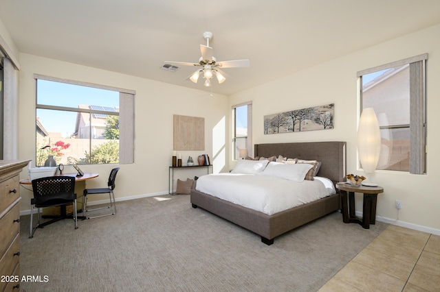 bedroom featuring ceiling fan, light tile patterned floors, and multiple windows