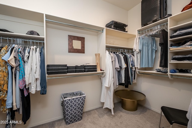 walk in closet featuring light colored carpet