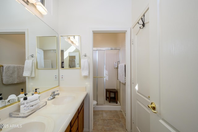 bathroom with toilet, tile patterned floors, a shower with shower door, and vanity