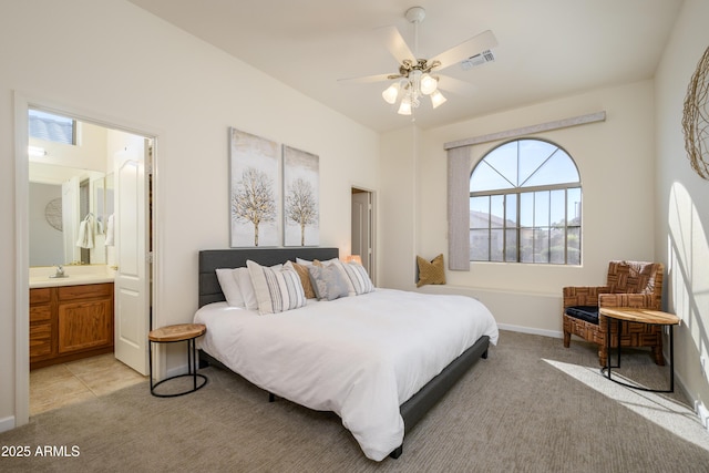 tiled bedroom featuring ceiling fan, sink, and ensuite bathroom