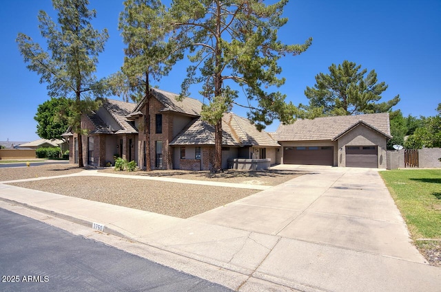 1750 E Mallory St, Mesa, AZ 85203 - view of front of home with an attached garage, driveway, a tiled roof, and stucco siding