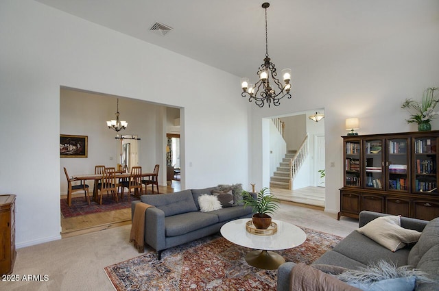 1750 E Mallory St, Mesa, AZ 85203 - living room featuring a chandelier, stairs, light colored carpet, and a towering ceiling