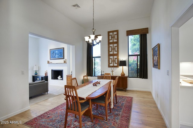 1750 E Mallory St, Mesa, AZ 85203 - dining area with light wood-style floors, a chandelier, and a fireplace