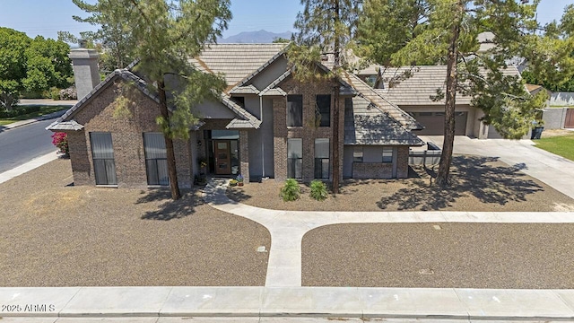 1750 E Mallory St, Mesa, AZ 85203 - view of front of property with concrete driveway, a chimney, brick siding, and a garage