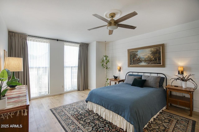1750 E Mallory St, Mesa, AZ 85203 - bedroom featuring light wood-type flooring, wooden walls, and a ceiling fan