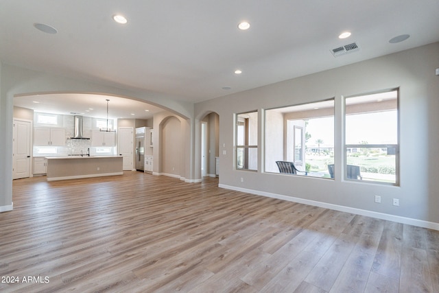 unfurnished living room featuring light hardwood / wood-style flooring and sink