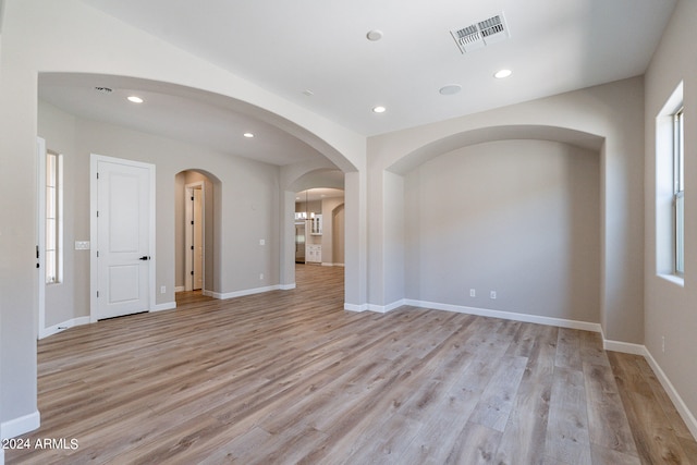 spare room with a wealth of natural light and light wood-type flooring