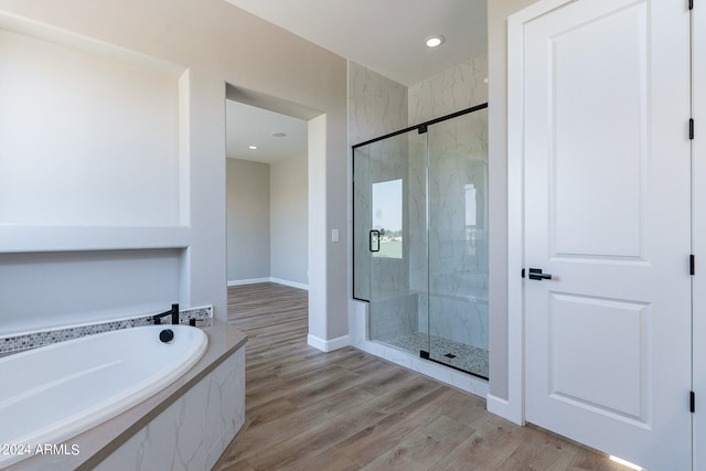 bathroom with shower with separate bathtub and hardwood / wood-style flooring