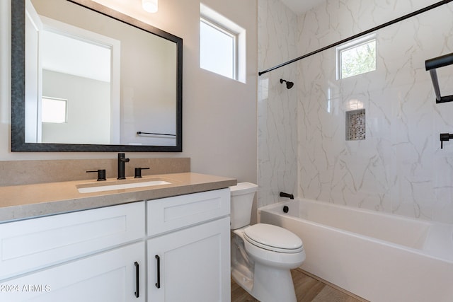 full bathroom with hardwood / wood-style flooring, toilet, vanity, and tiled shower / bath