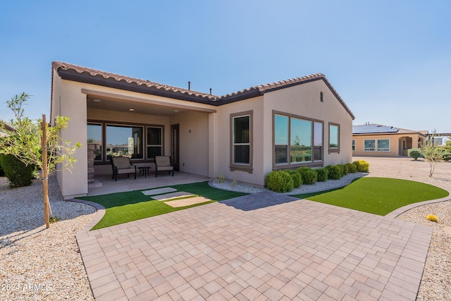 back of property with a patio and an outdoor living space