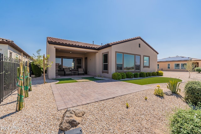 rear view of property featuring a patio and outdoor lounge area