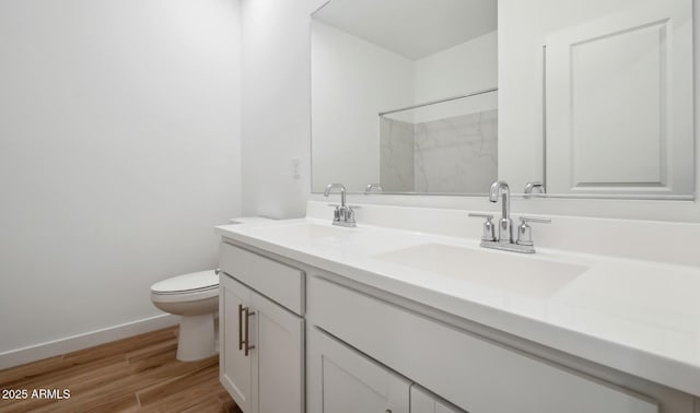 bathroom with hardwood / wood-style flooring, vanity, toilet, and walk in shower