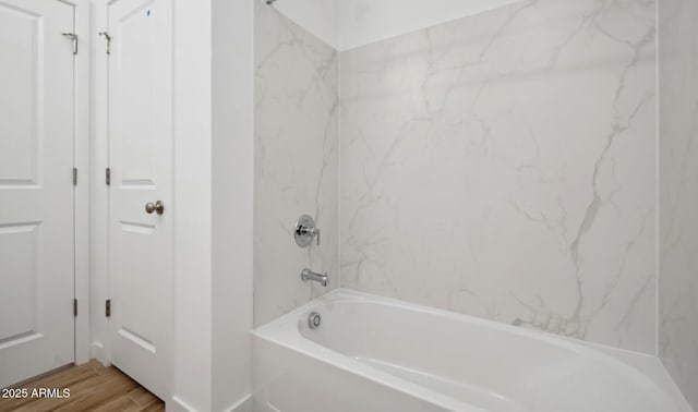 bathroom with wood-type flooring and  shower combination