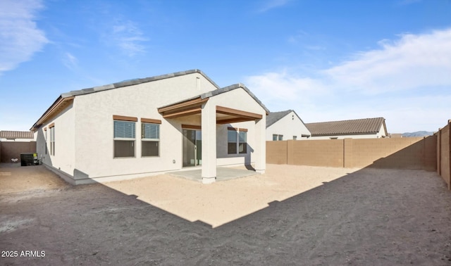 rear view of property with central AC unit and a patio area