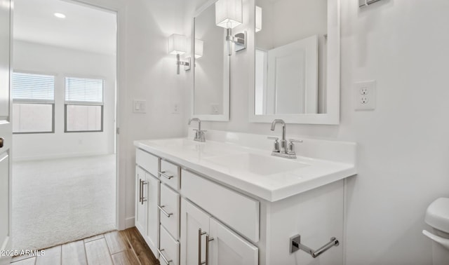 bathroom with vanity, hardwood / wood-style floors, and toilet