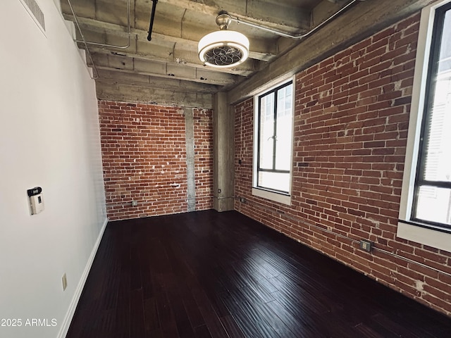 114 W Adams St Unit 302, Phoenix, AZ 85003 - spare room featuring brick wall, wood-type flooring, healthy amount of natural light, and baseboards
