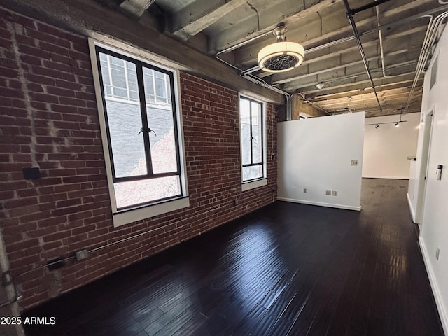 114 W Adams St Unit 302, Phoenix, AZ 85003 - empty room with brick wall, wood finished floors, and baseboards