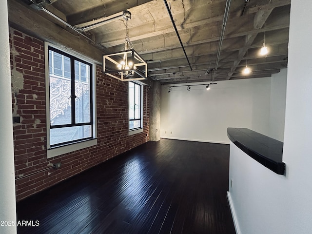 114 W Adams St Unit 302, Phoenix, AZ 85003 - basement featuring brick wall, hardwood / wood-style floors, a chandelier, and rail lighting