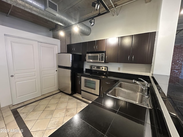 114 W Adams St Unit 302, Phoenix, AZ 85003 - kitchen featuring stainless steel appliances, a sink, dark countertops, light tile patterned flooring, and a high ceiling