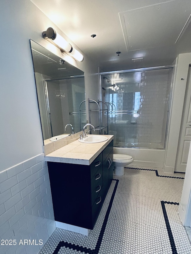 114 W Adams St Unit 302, Phoenix, AZ 85003 - bathroom with vanity, wainscoting, combined bath / shower with glass door, toilet, and tile walls