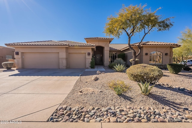 mediterranean / spanish home featuring a tiled roof, stucco siding, an attached garage, and driveway