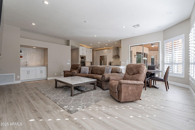 living area featuring light wood finished floors, visible vents, and recessed lighting