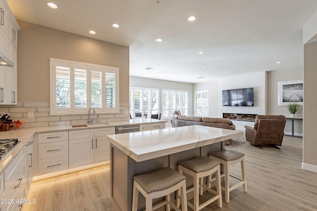 kitchen featuring white cabinetry, stainless steel appliances, a kitchen bar, and a sink