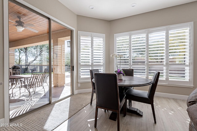 dining area featuring light wood-type flooring, baseboards, and ceiling fan