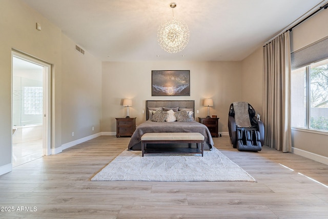 bedroom with visible vents, baseboards, ensuite bath, light wood-style floors, and a notable chandelier