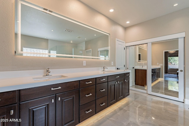 bathroom with a sink, visible vents, recessed lighting, and double vanity