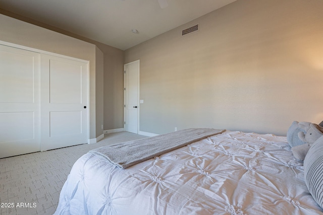 bedroom with baseboards, visible vents, and a closet