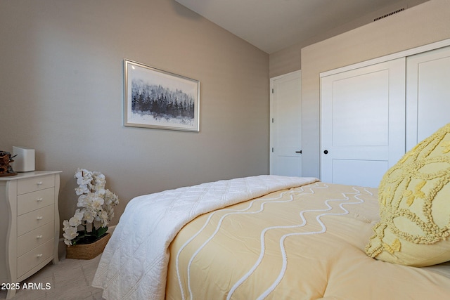 bedroom featuring a closet, visible vents, and vaulted ceiling