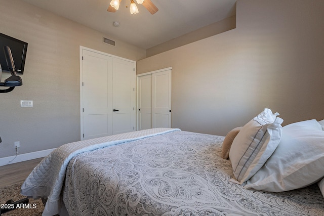 bedroom featuring a ceiling fan, wood finished floors, visible vents, baseboards, and a closet