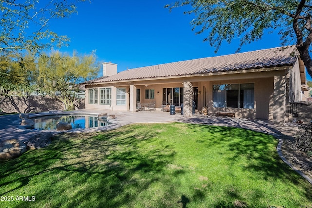 back of property with a patio, fence, a yard, an outdoor pool, and a chimney